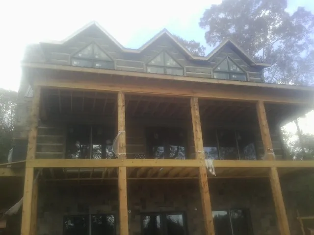 Dormers and porch framing on a large log home under construction — Roof Coating work by our crew in Wauseon